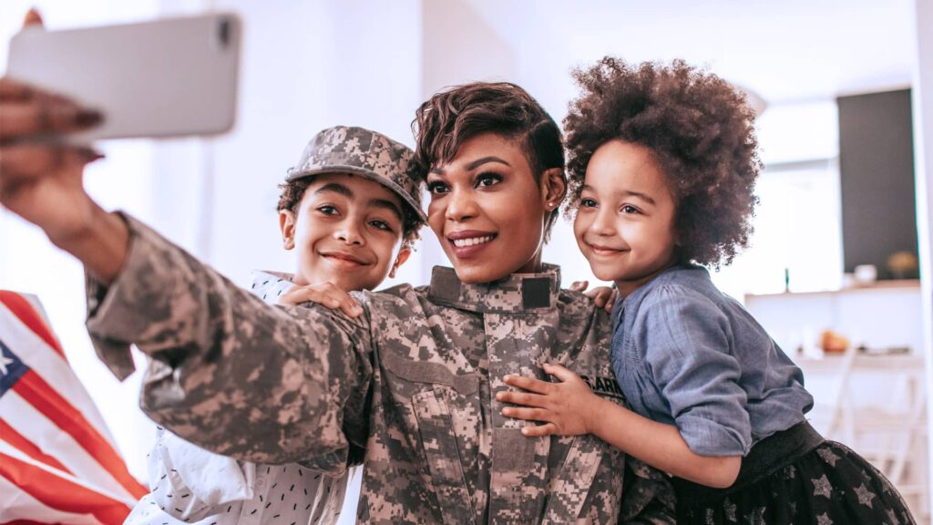 Military Discounts fromAT&T. Image shows active duty mother taking a selfie with her son and daughter