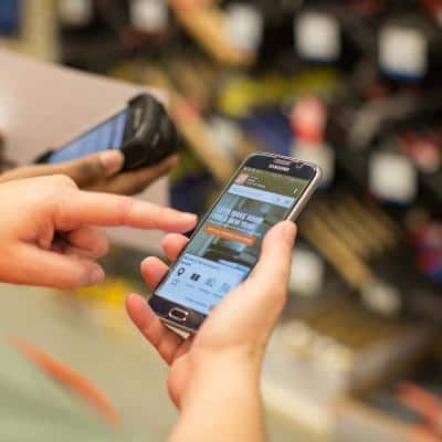 Someone holding a phone on the Home Depot mobile website checking out current Rebates