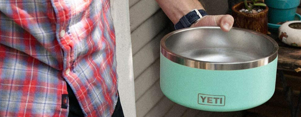 Man holding a YETI dog bowl in Teal color